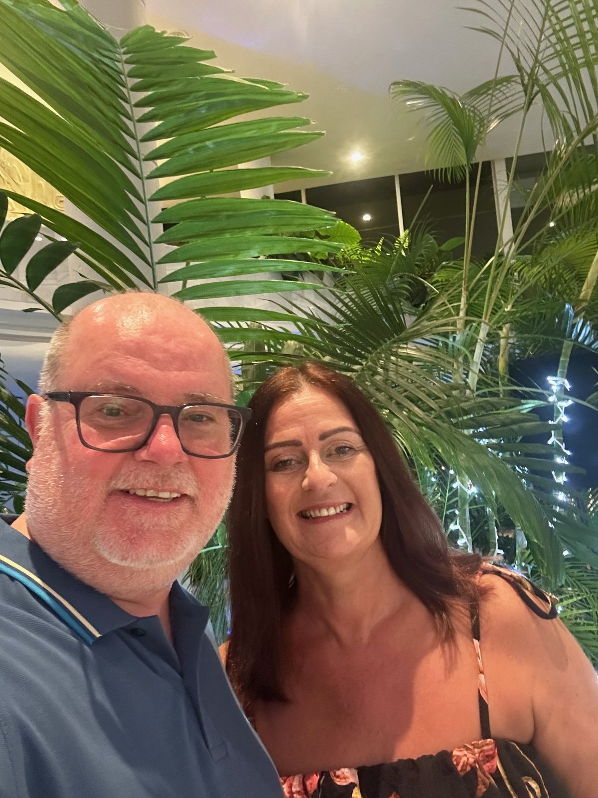 Chris and Sarah smiling together among the hotel’s greenery