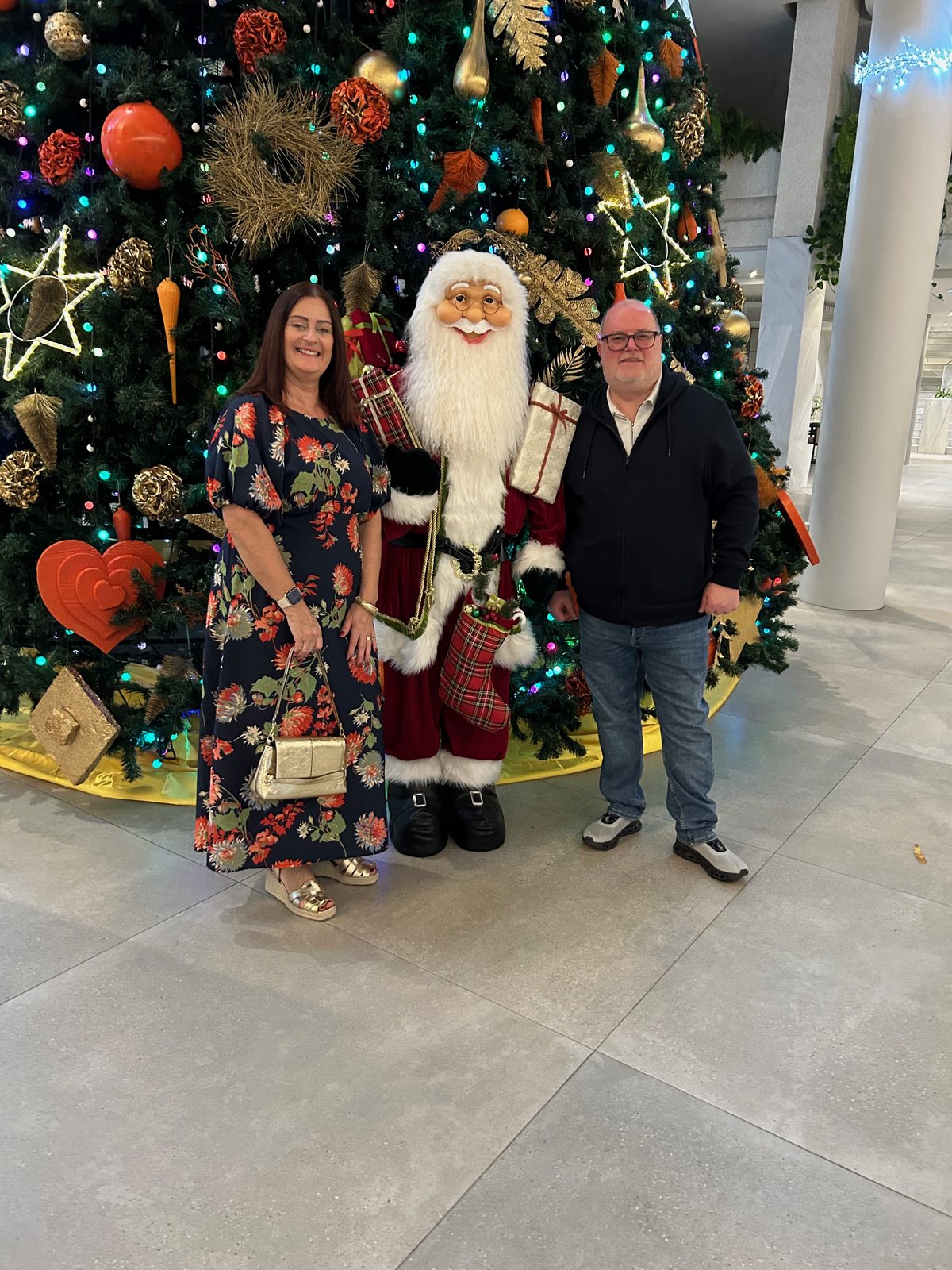 Chris and Sarah standing either side of Father Christmas in front of the hotel’s decorated tree