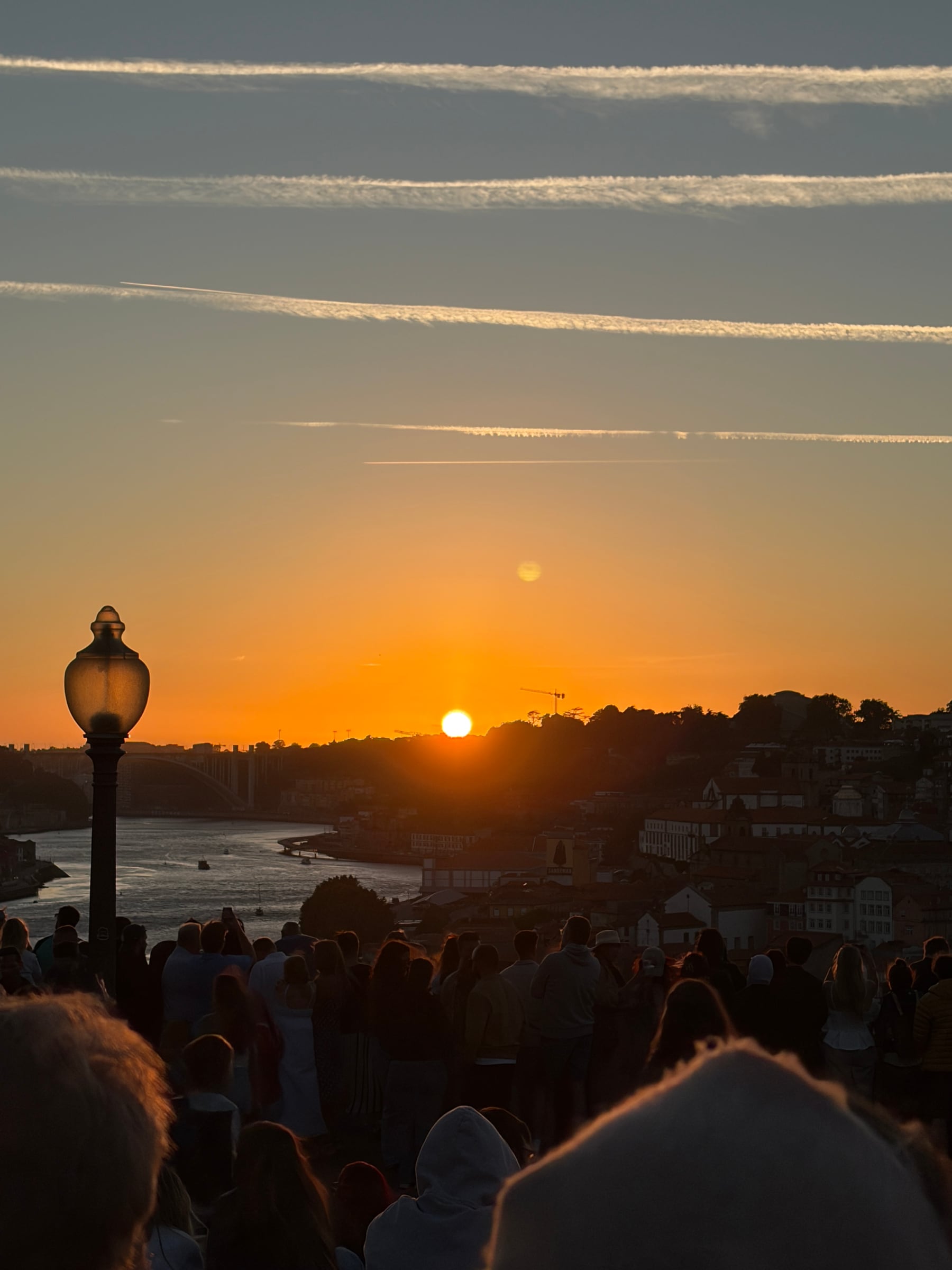 Sunset over Porto and the River Douro, seen above a gathered crowd