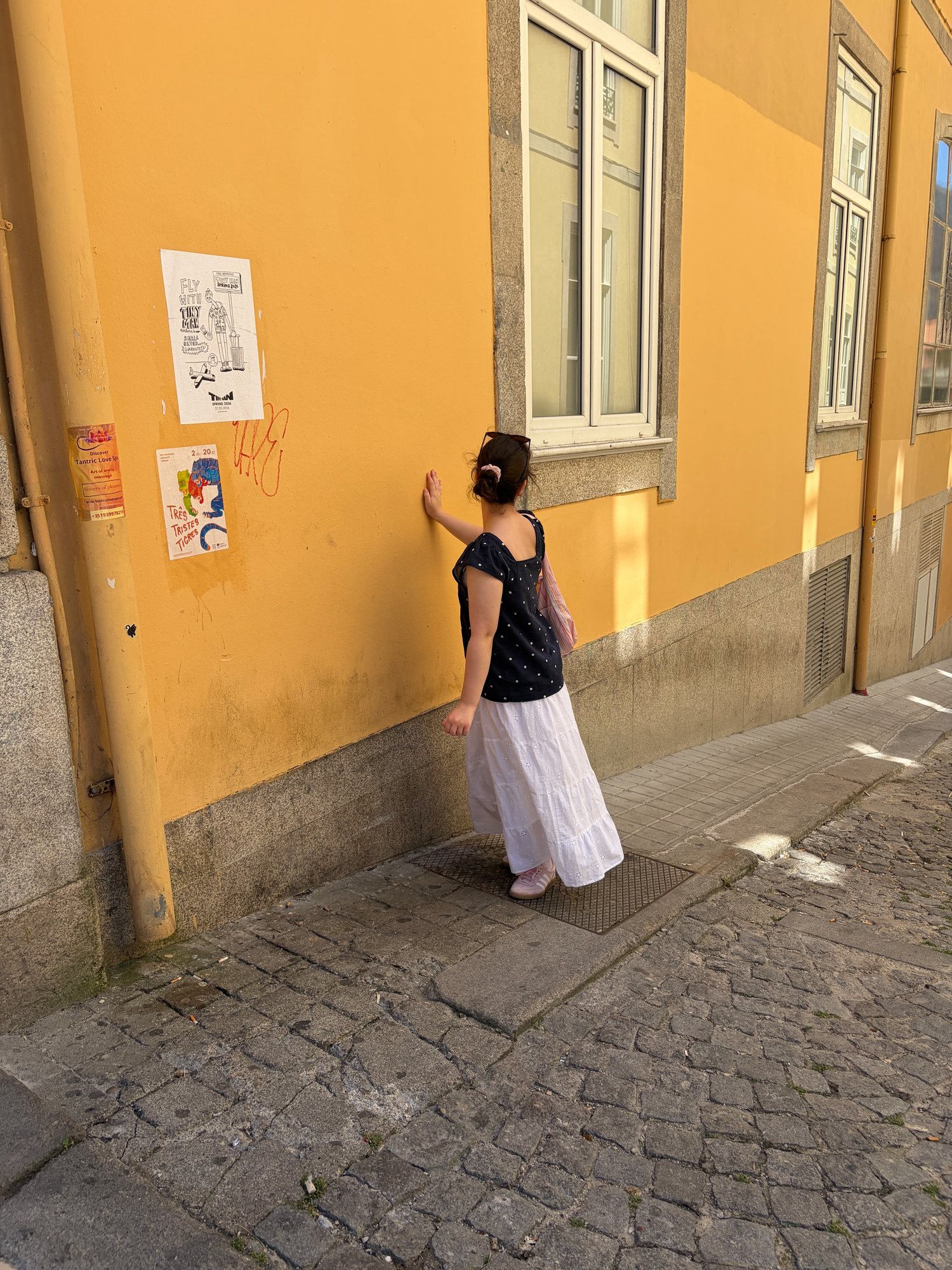 Sally beside a warm yellow wall near Bolhão in Porto