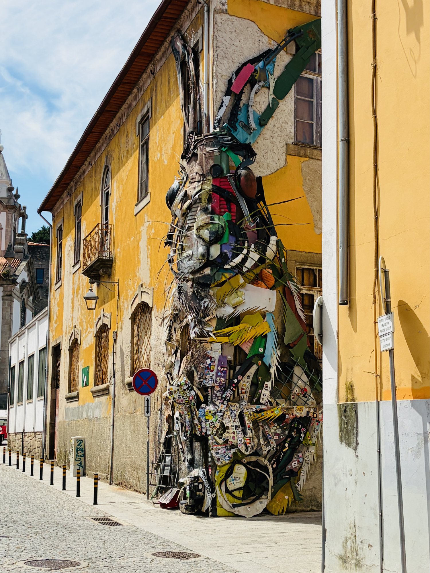 Colourful street art climbing a yellow building in Vila Nova de Gaia