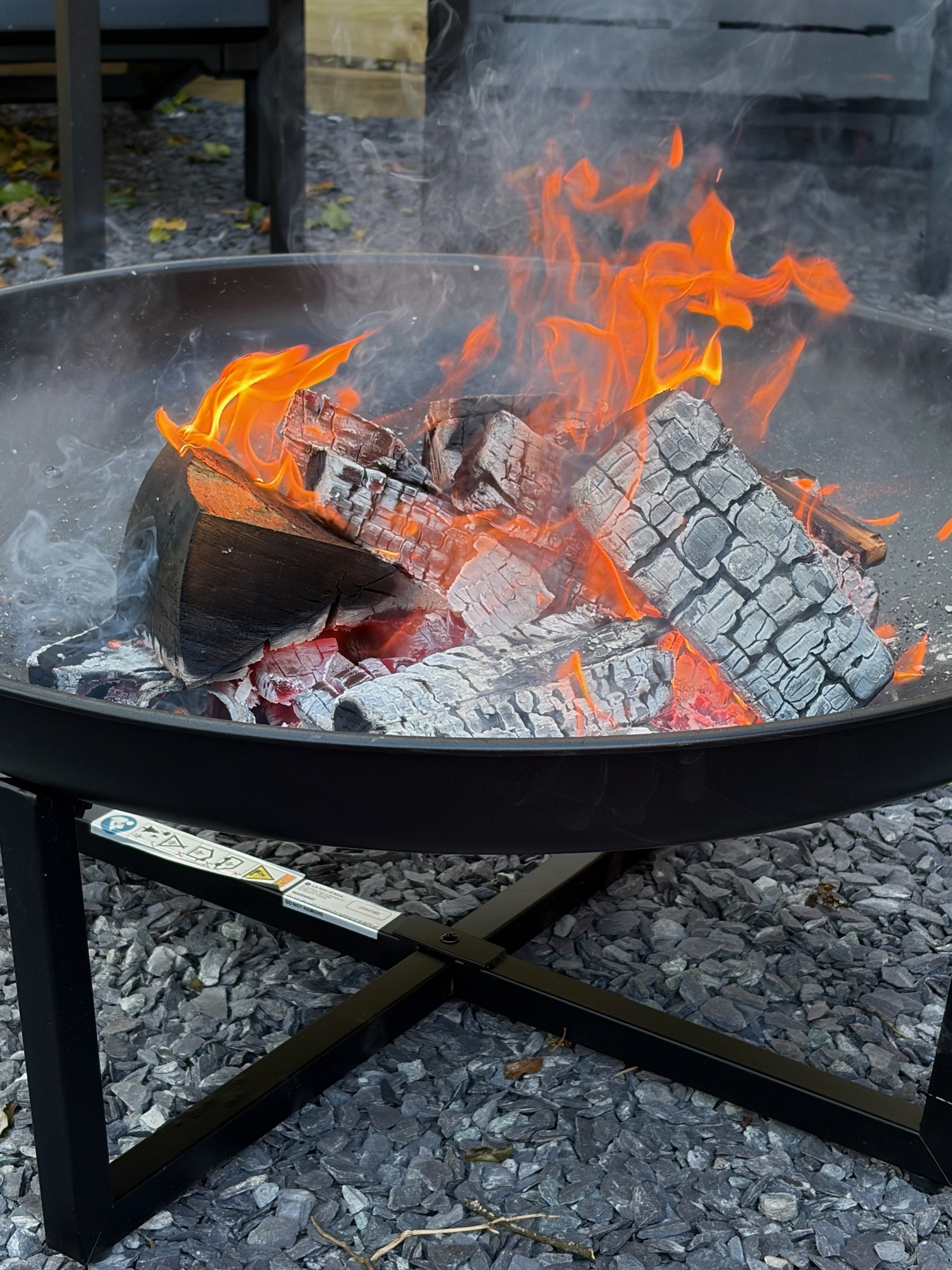 Logs burning brightly in the outdoor fire pit